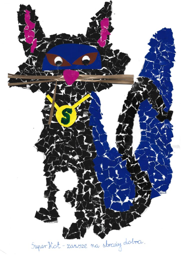 Praca nagrodzona 1. miejscem. Czarny kot, w granatowej pelerynie wykonany metodą wydzieranki. Praca jest opisana następującymi słowami: „Super Kot – zawsze na straży dobra”.