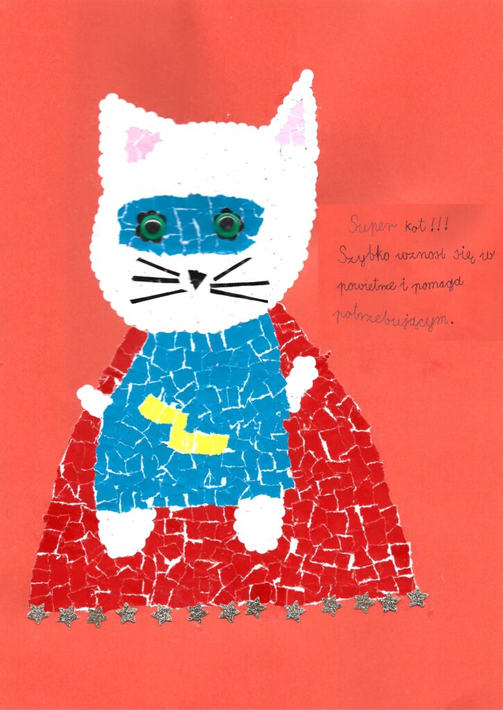 raca nagrodzona 2. miejscem, przedstawia białego kota w stroju Supermana na czerwonym tle. Kot jest wykonany metodą wydzieranki. Praca jest opisana następującymi słowami: „Super kot!!! Szybko wznosi się w powietrze i pomaga potrzebującym”.