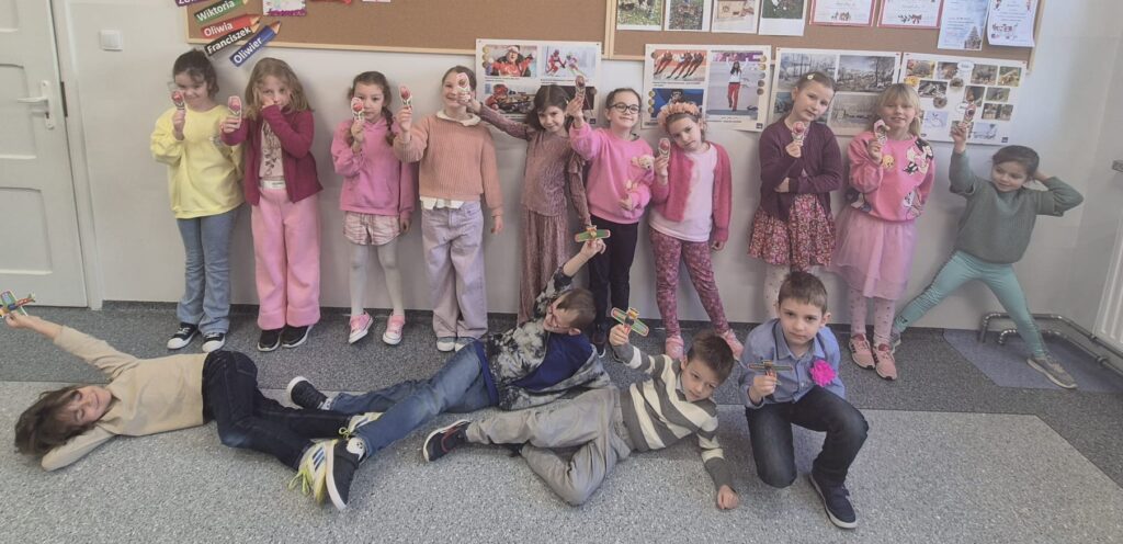 Zdjęcie przedstawia uczniów klasy 1c. Chłopcy pozują w pierwszym rzędzie, a za nimi stoją dziewczynki ubrane na różowo.
