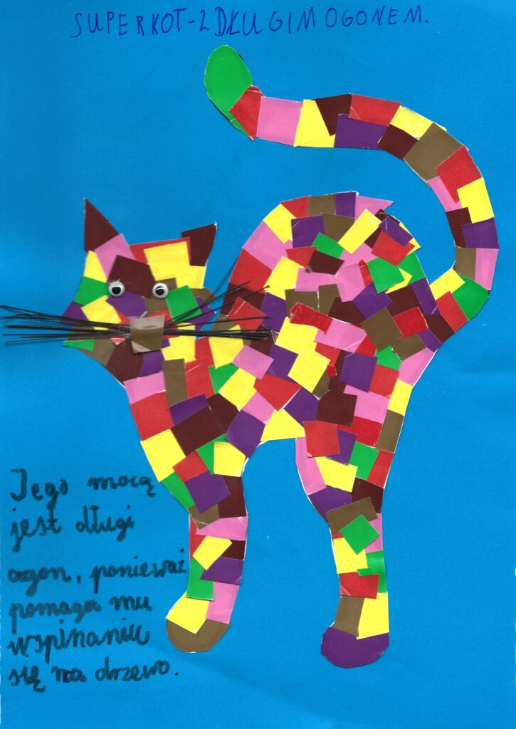 Druga z wyróżnionych prac. Przedstawia kota wykonanego techniką wycinanki o sierści składającej się z różnokolorowych kwadratów. Podpis: „SUPER KOT Z DŁUGIM OGONEM. Jego mocą jest długi ogon, ponieważ pomaga mu wspinać się na drzewo”.