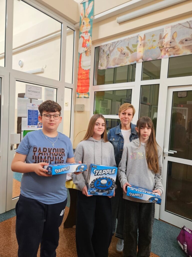 Na zdjęciu troje uczniów. Laureaci konkursu plastycznego o tematyce profilaktycznej. Od lewej :  dziewczynka Lena Łoś, w środku chłopiec Adrian Ratajczak, ostatnia dziewczynka Lena Kroczak. Uczniowie stoją a w rękach trzymają prace konkursowe. Plakaty przedstawiające ofiary uzależnienia od telefonów i mediów społecznościowych.