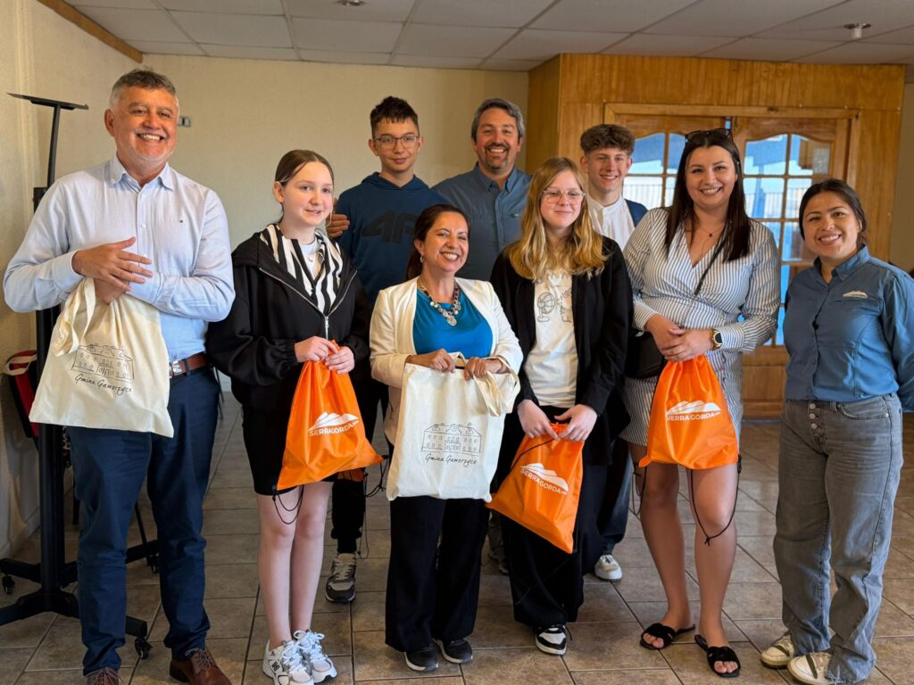 Nasi uczniwoie dotarli do Chile. Na zdjęciu uczniowie z Polski wraz z przedstawicielami gminy Sierra Gorda. Uczniowie z Polski trzymają podarunki od przedstawicieli Sierra Gorda, a przedstawiciele Sierra Gorda trzymają podarunki od gminy Gaworzyce. 