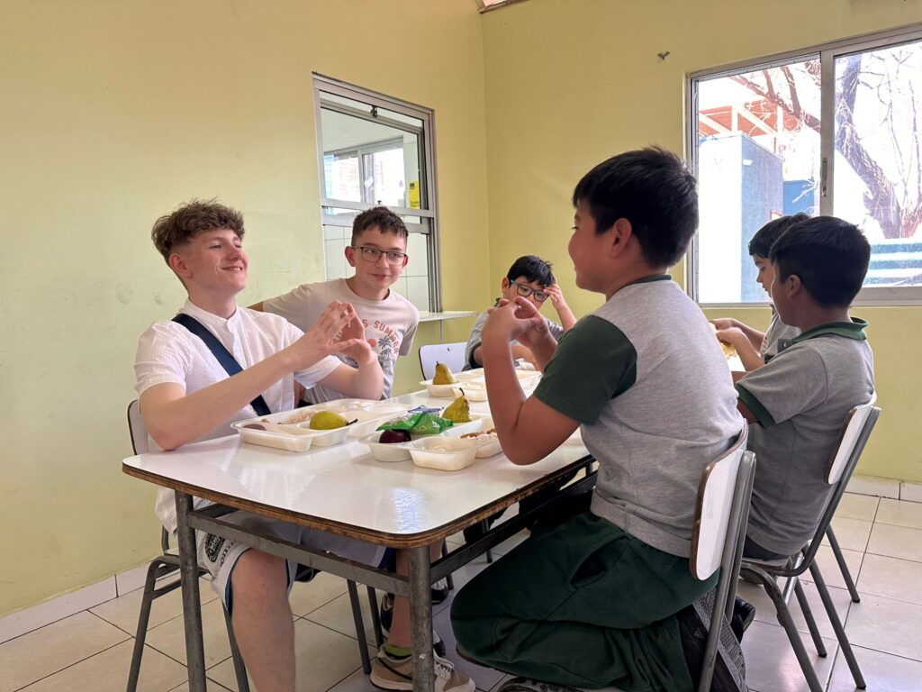 Nasi uczniwoie dotarli do Chile. Na zdjęciu uczniowie z Polski wraz z uczniami chilijskimi podczas spożywania posiłku na stołówce. 