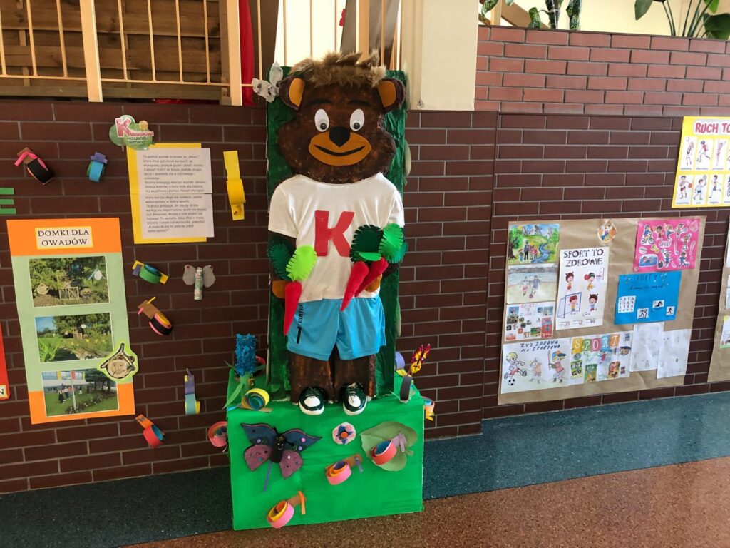 Program edukacyjny „Kubusiowi Przyjaciele Natury”. Na zdjęciu prace uczniów na temat zdrowego trybu życia, aktywności sportowej. Na środku zdjęcia znajduje się Kubuś- maskotka firmy promującej soki i musy. 