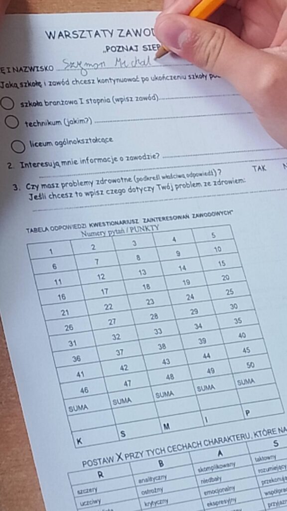 Przedstawia arkusz (czarna czcionka na białym tle) wykorzystany podczas warsztatów. Zawiera on pytania dot. predyspozycji i zawodów oraz tabelkę z numerami pytań i punkty. 