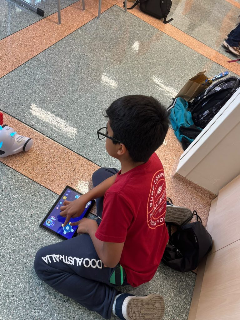 Na zdjęciu widzimy jednego z uczestników międzynarodowych warsztatów robotyki, który z dużym skupieniem steruje robotem edukacyjnym Photon za pomocą tabletu. Korzystając ze specjalnej aplikacji, chłopiec wydaje robotowi polecenia i obserwuje jego zachowanie.
Zajęcia pozwoliły uczniom w praktyczny sposób poznawać podstawy programowania, rozwijać logiczne myślenie, koncentrację oraz umiejętność rozwiązywania problemów.