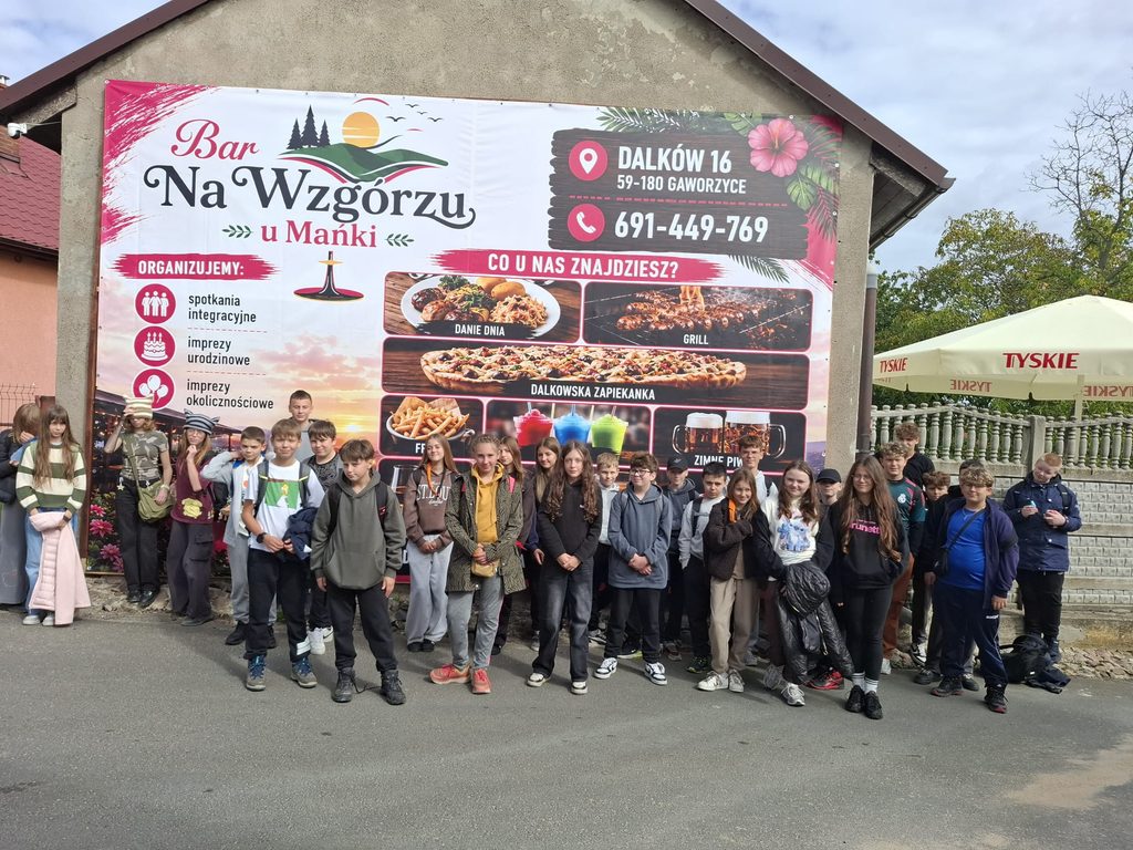 Na zdjęciu wszyscy uczestnicy wycieczki stojący przed barem ,,Na Wzgórzu u Mańki"